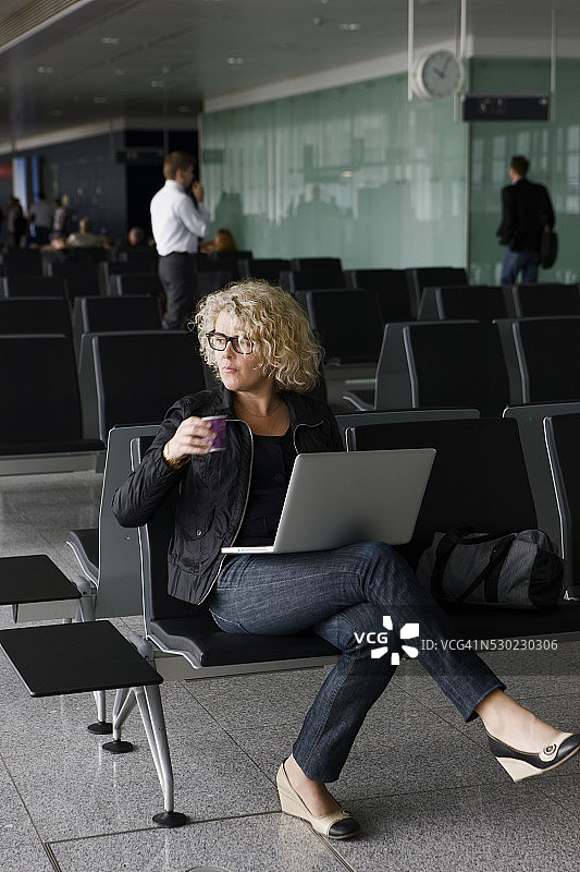 在德国法兰克福机场使用笔记本电脑的中年妇女图片素材