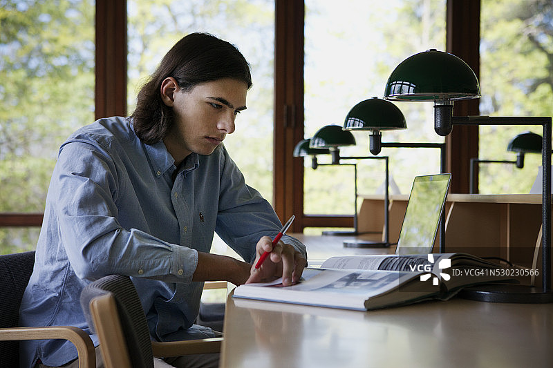在图书馆学习的年轻男人图片素材