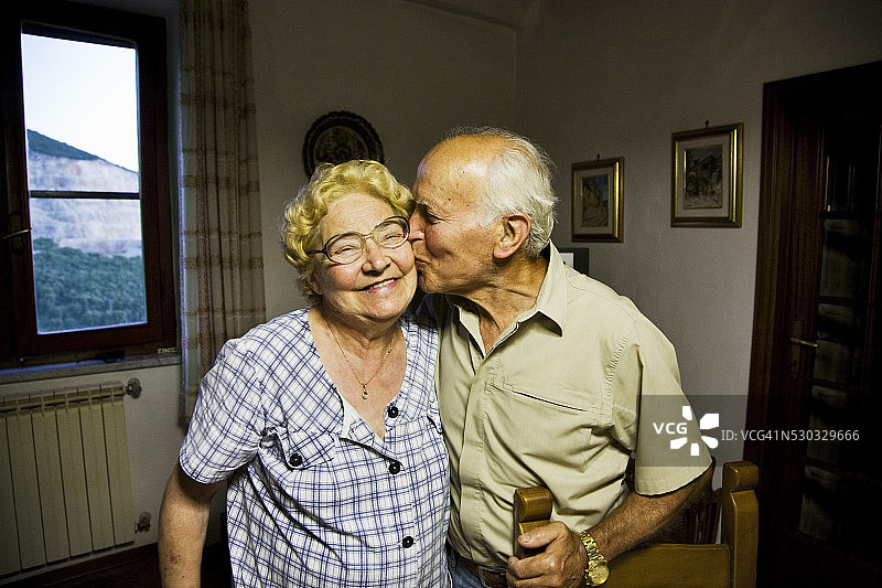 年长的男人亲吻年长的女人的脸颊图片素材