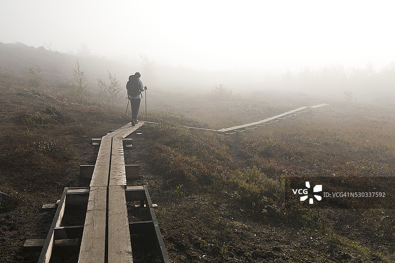 在木栈道上行走的青少年男孩图片素材