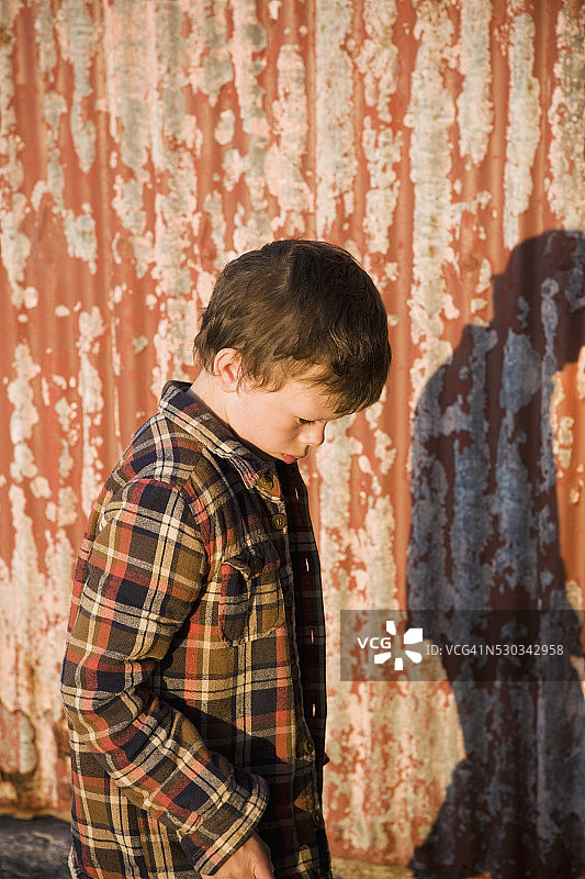 靠在金属墙上的男孩图片素材