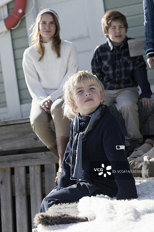 孩子们坐在木制建筑前图片素材