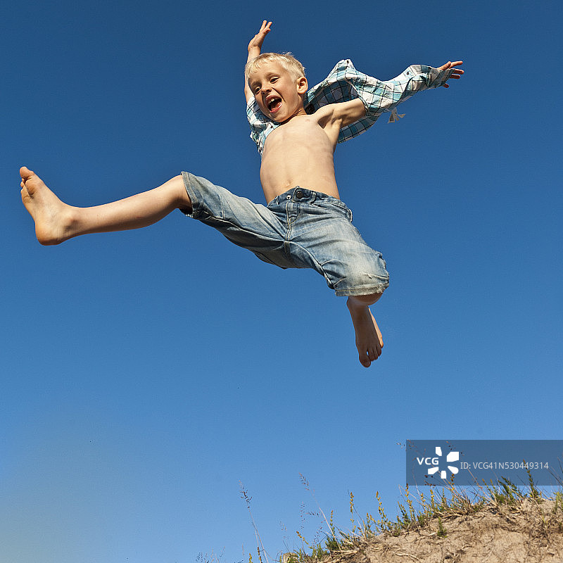 男孩跳跃的低角度视图图片素材