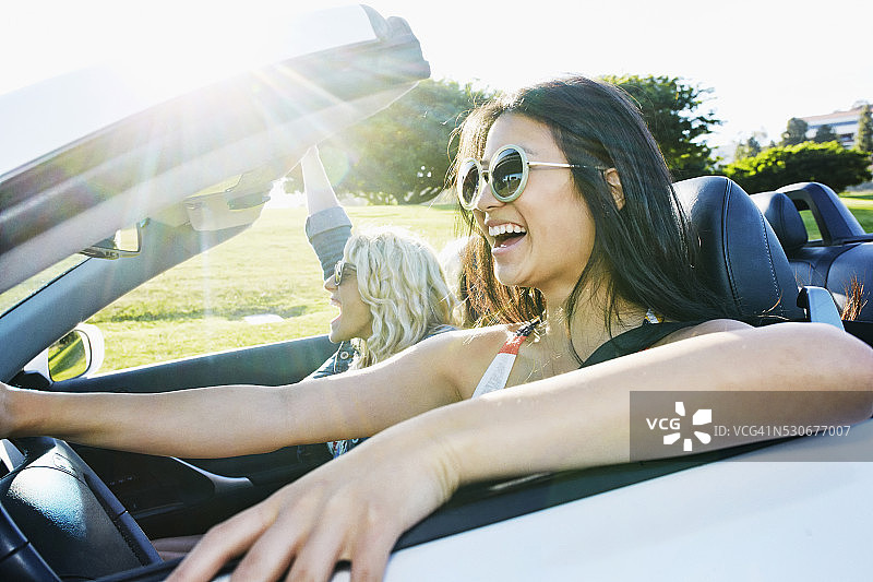 在公路旅行中驾驶敞篷车的兴奋女人们图片素材