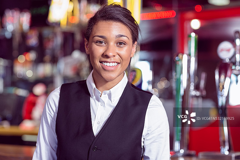 对着镜头微笑的漂亮女酒保图片素材
