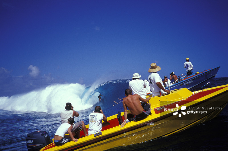 在船上拍摄冲浪者的摄影师图片素材