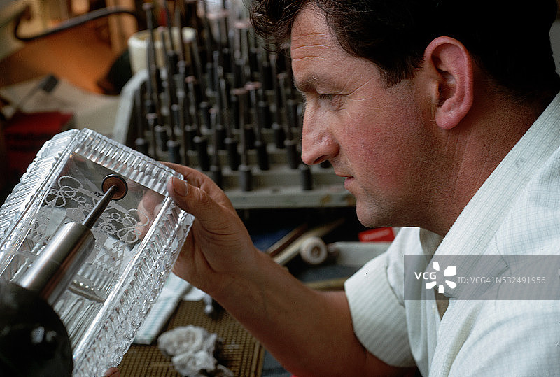 在铅晶花瓶上工作的雕刻师图片素材