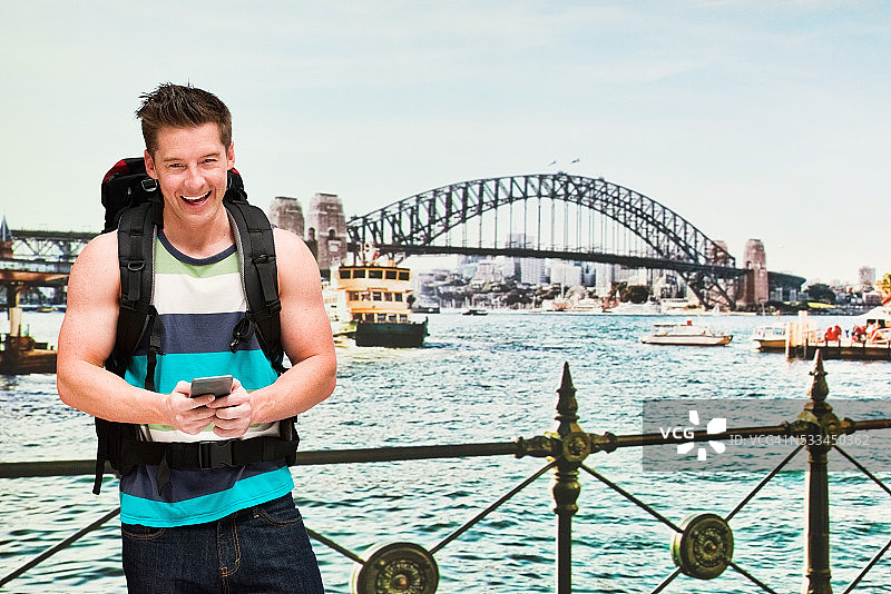 使用手机的微笑背包客图片素材