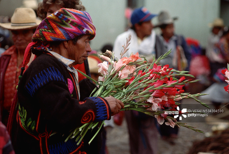 在周日市场拿着鲜花的男人图片素材