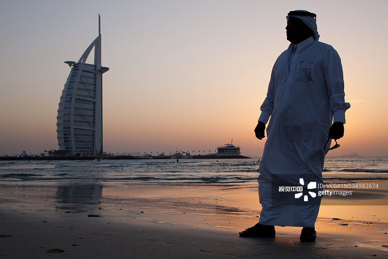 身穿阿拉伯长袍的男人与迪拜阿拉伯塔，阿联酋图片素材