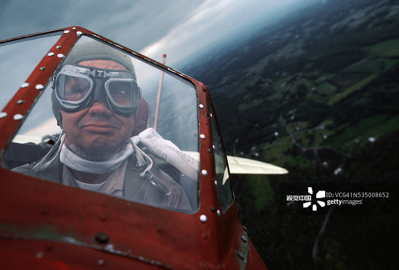 驾驶舱内的飞行员和下方的乡村图片素材