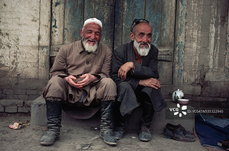 老年维吾尔族男人在台阶上交谈图片素材