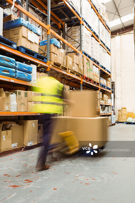 工人推动装有箱子的手推车（模糊效果）图片素材