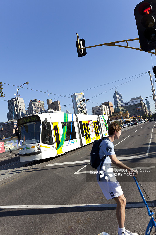 青少年在墨尔本圣基尔达路玩滑板车图片素材