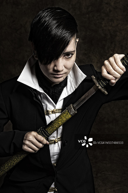 年轻亚洲男人斜向拔出武士刀的粗犷图像图片素材