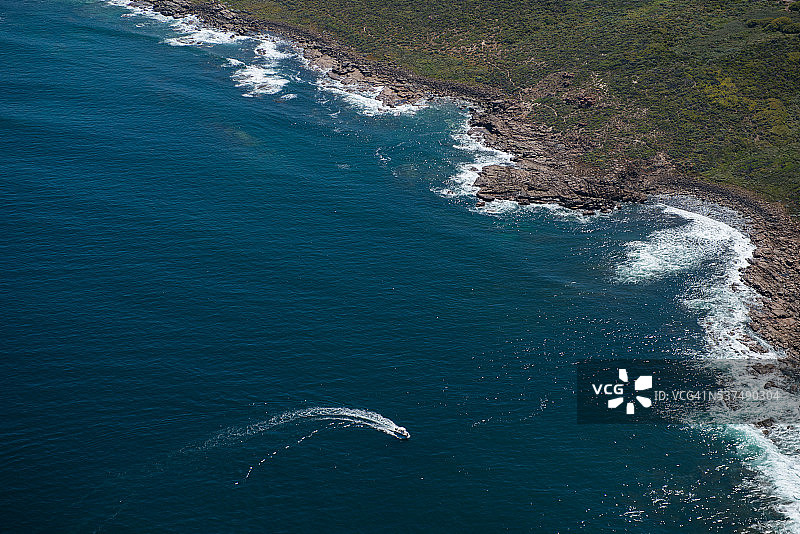 靠近岩石海岸线行驶的船只鸟瞰图图片素材