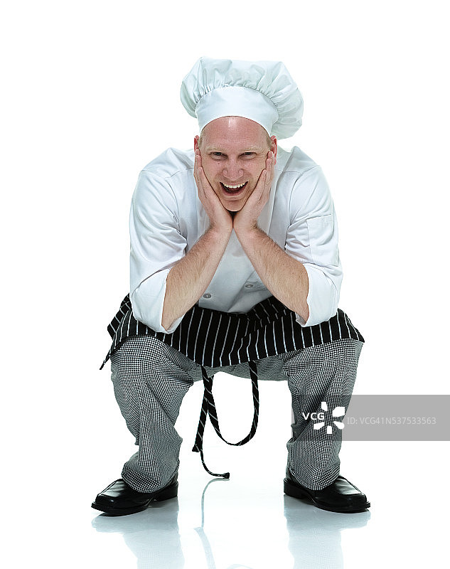 快乐的厨师蹲着看着镜头图片素材