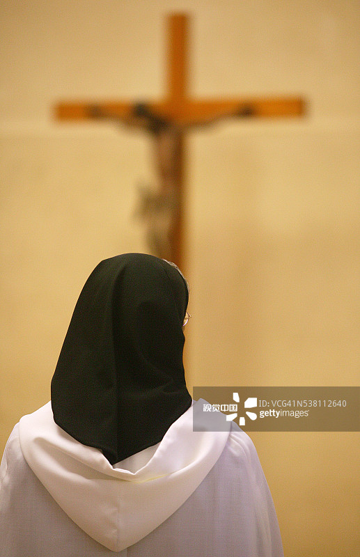 站在十字架前的修女图片素材