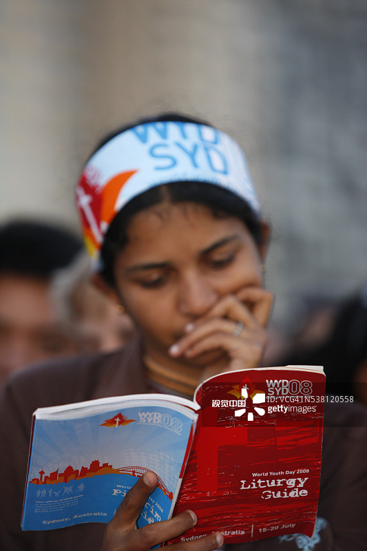 年轻女人在世界青年日阅读礼拜仪式图片素材