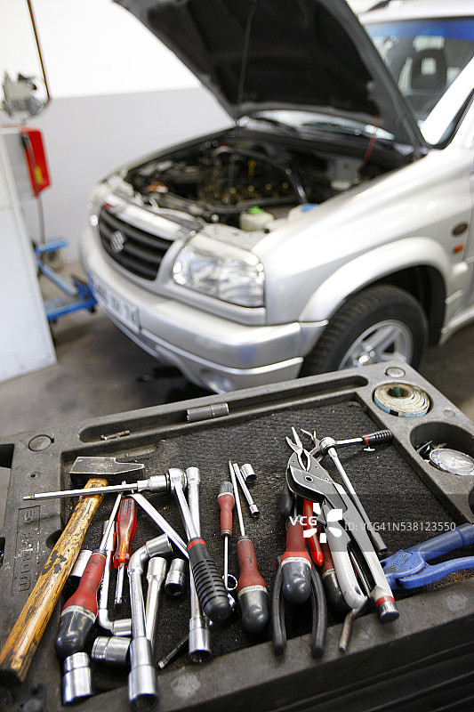 汽车修理店里SUV旁边的汽车修理工具图片素材