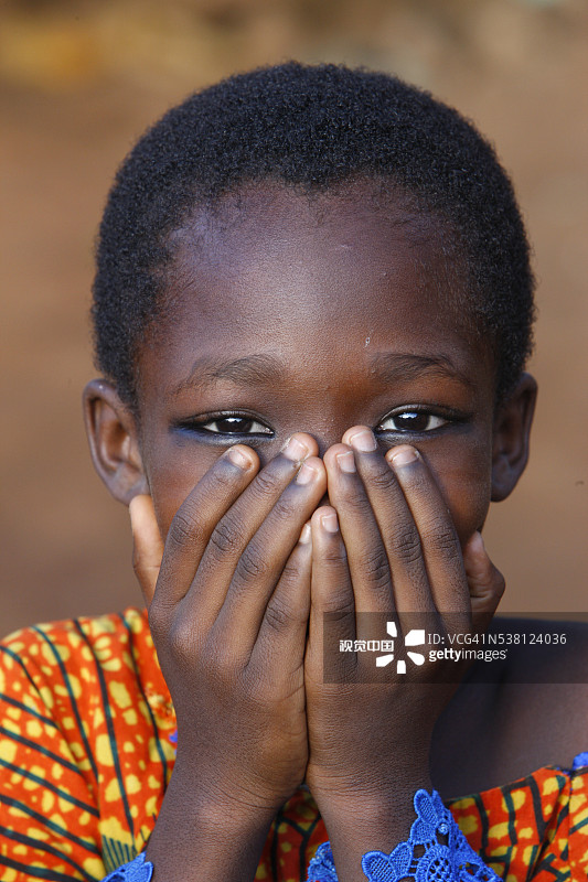 躲在手后面的多哥男孩图片素材