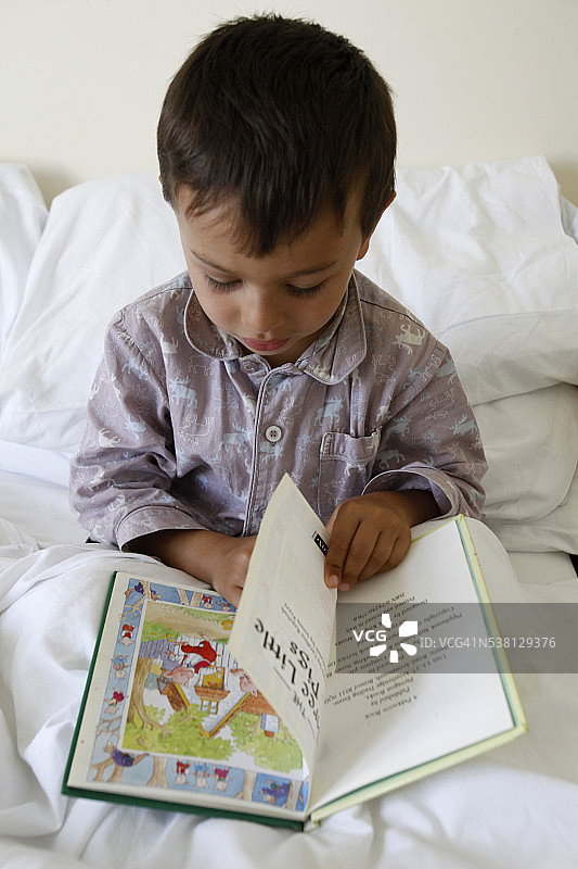 正在阅读故事的4岁男孩图片素材