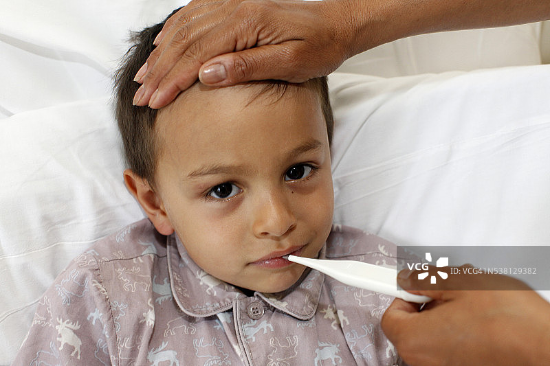 生病的男孩在量体温图片素材