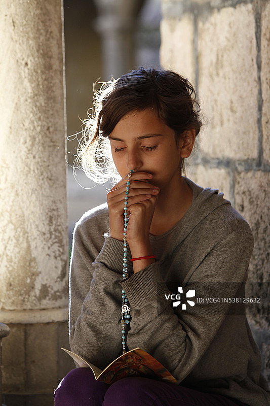 在回廊里祈祷的青少年图片素材