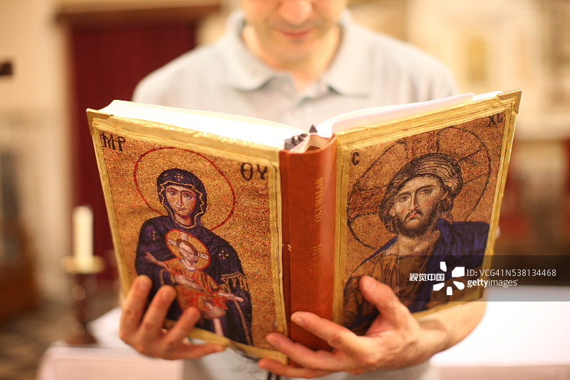 男人在圣彼得和圣保罗教堂阅读圣经图片素材