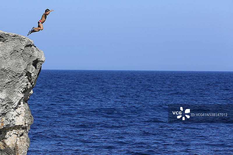 从悬崖上跳下来的6岁男孩图片素材