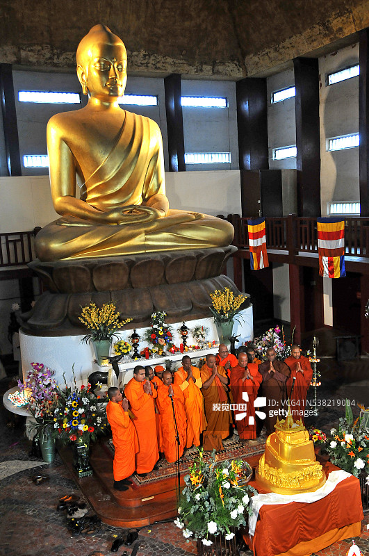 万森讷佛塔：巴黎佛陀舍利展，僧侣在大佛像前祈祷图片素材
