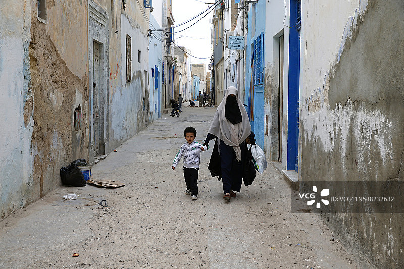 母亲和儿子在莫纳斯提尔麦地那（老城区）散步图片素材