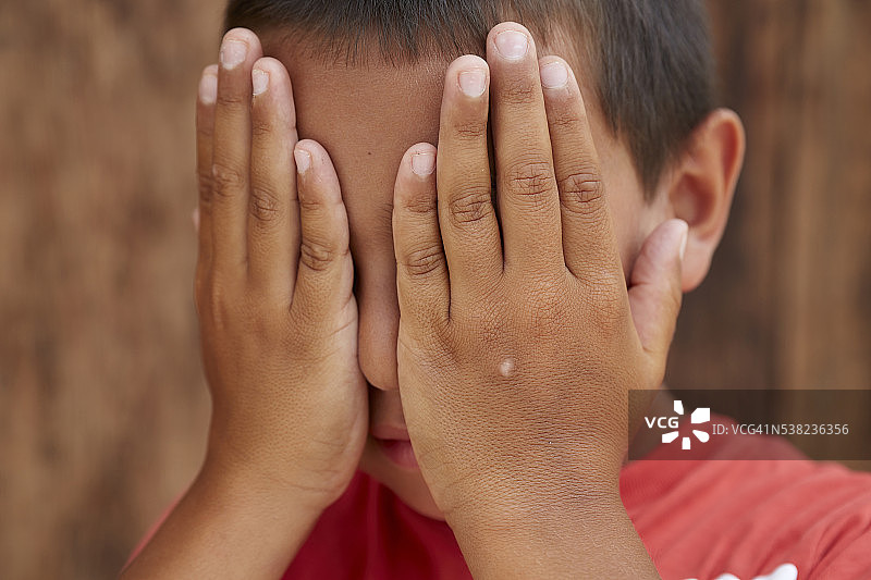 男孩遮住脸图片素材