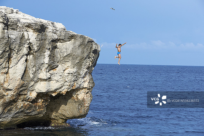 男孩跳下悬崖图片素材