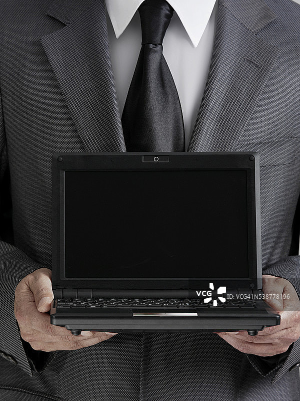 商人手持笔记本电脑图片素材