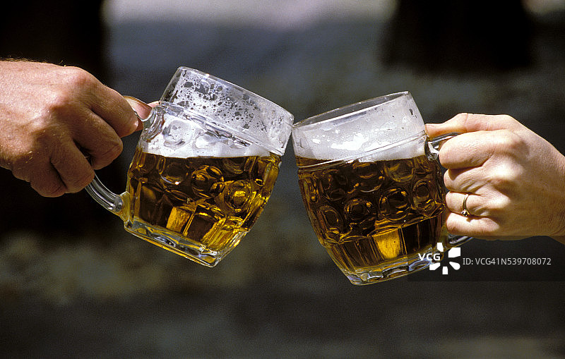 人们举着啤酒杯敬酒图片素材