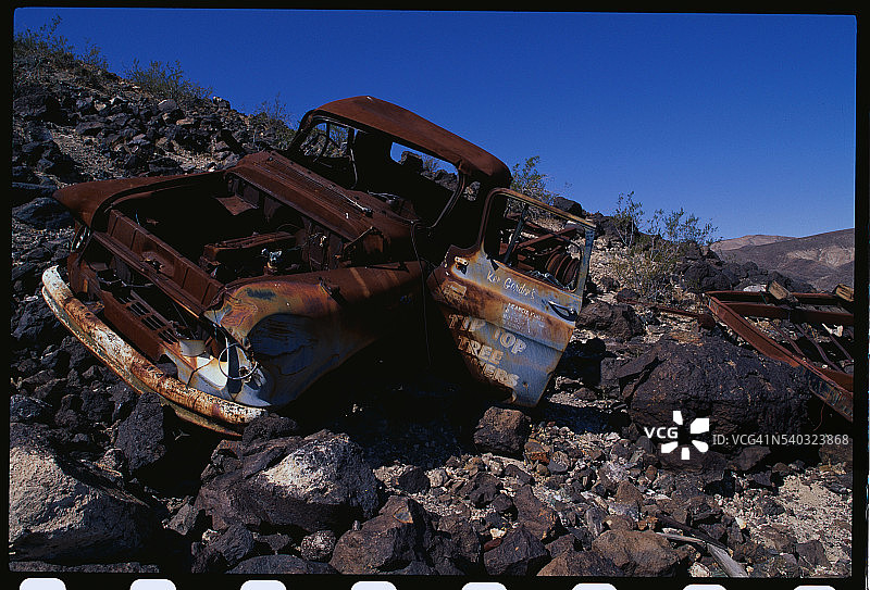 岩石山坡上锈迹斑斑的车辆图片素材