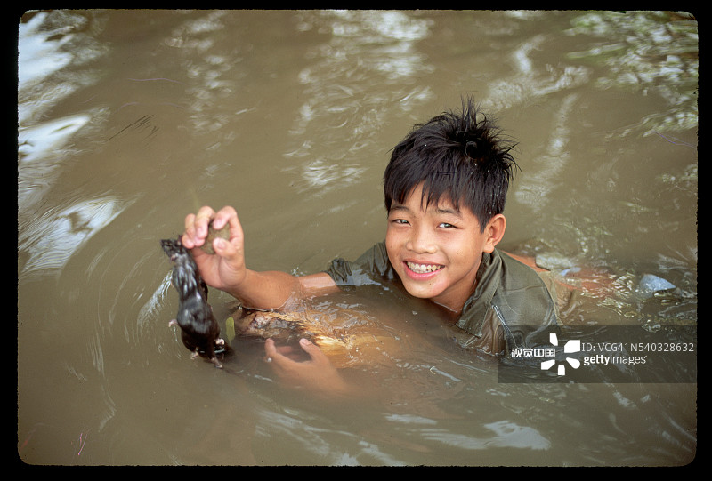 男孩在河里捕鼠图片素材