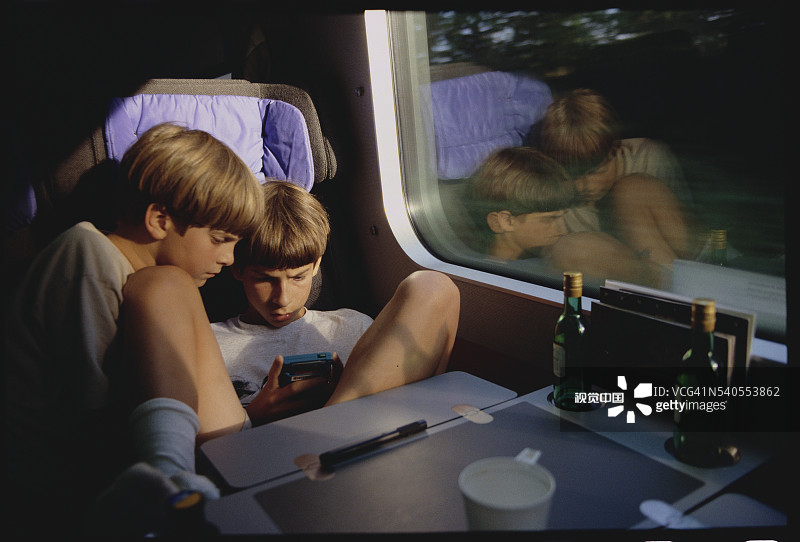 在火车上玩电子游戏的兄弟图片素材