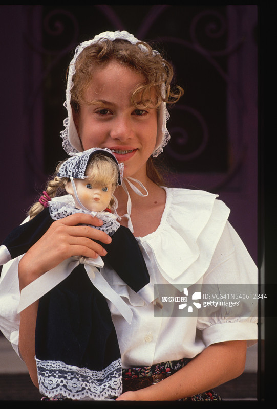 穿着殖民时期服装的女孩和玩偶图片素材