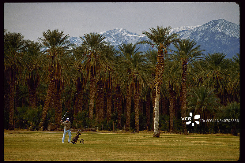 高尔夫球手在球道上挥杆图片素材