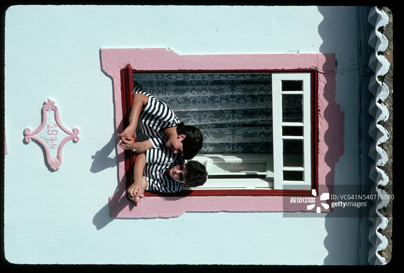 两名女孩从窗户向外看图片素材