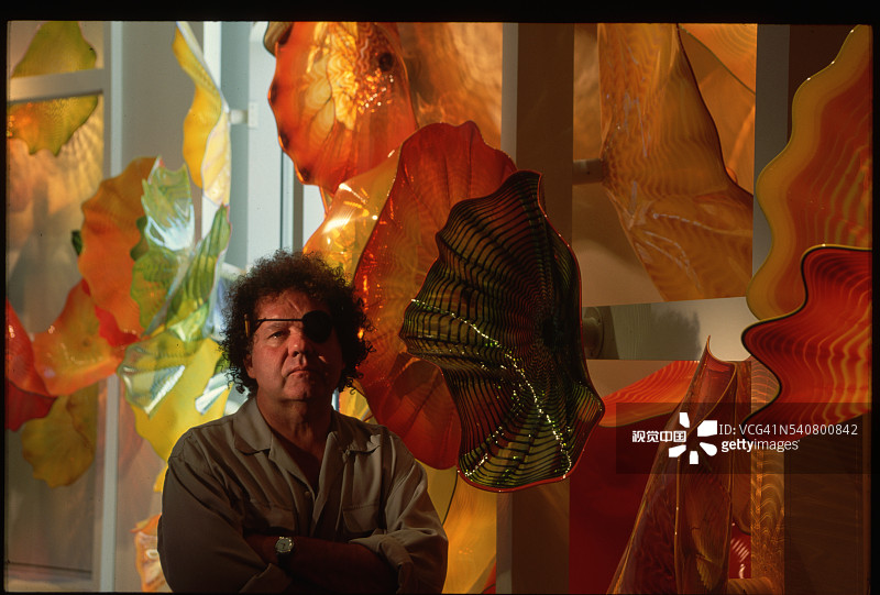 戴尔·奇胡利站在他的玻璃艺术品旁图片素材