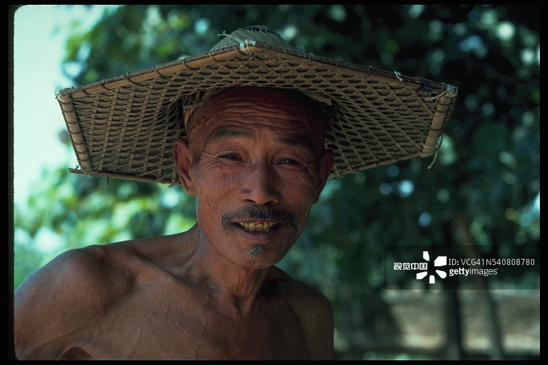 戴六角草帽的农民图片素材