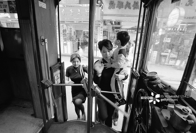 香港街头家庭乘坐有轨电车图片素材