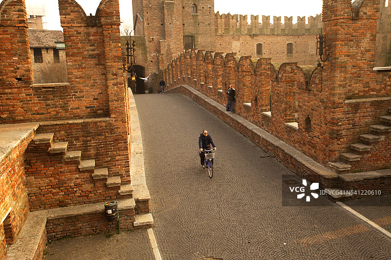 骑自行车穿过斯卡利杰罗桥的男子图片素材