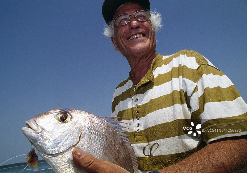 手持鱼的法国渔夫图片素材