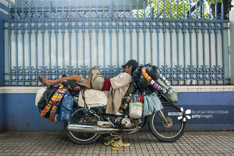 男人睡在摩托车上图片素材