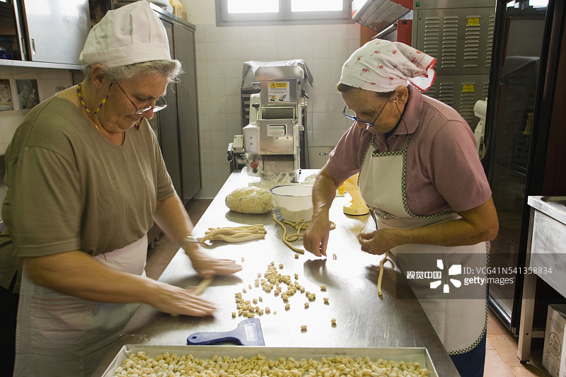 在餐厅厨房做意大利面的女性图片素材