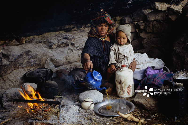 柏柏尔族母亲在洞穴住所里倒茶图片素材